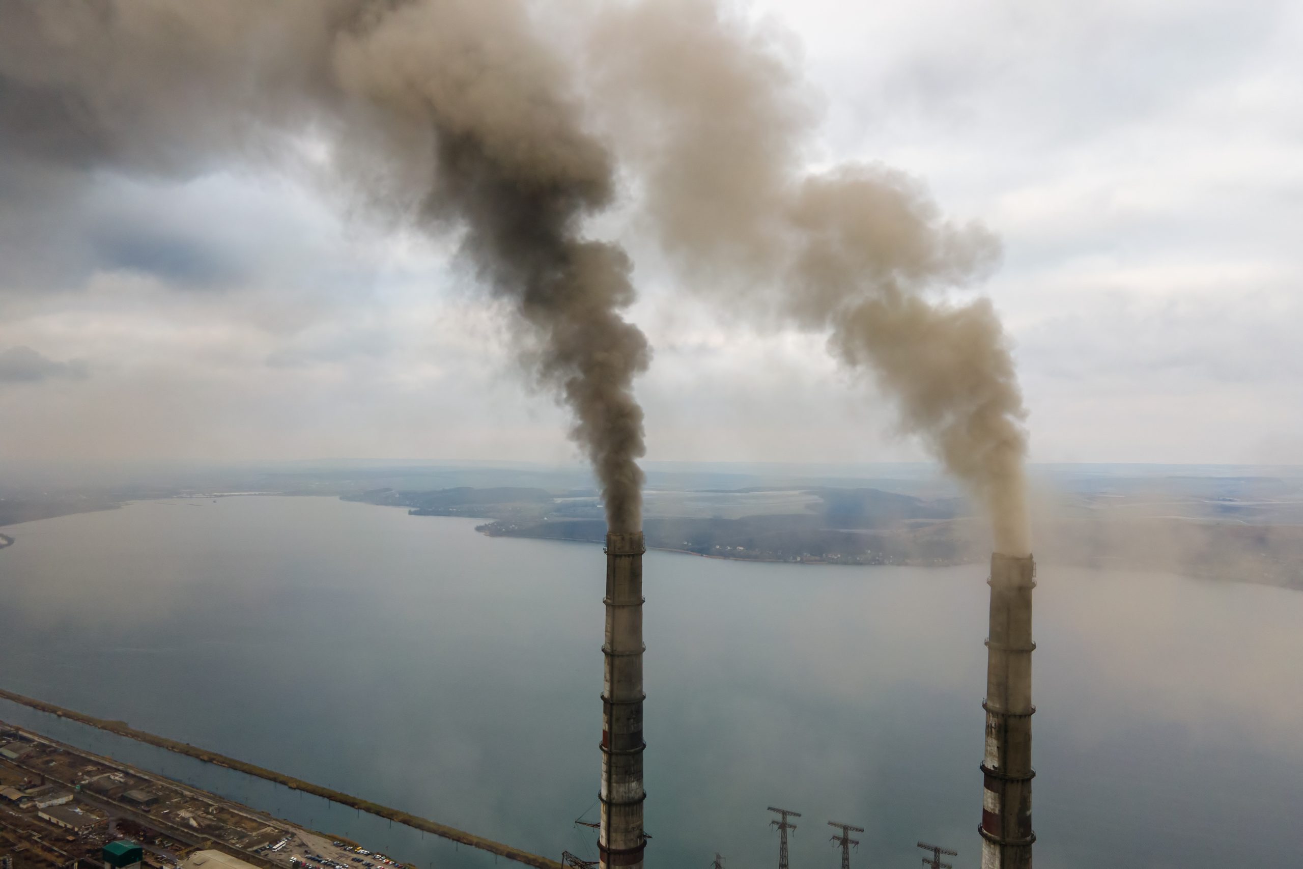 Aerial view of coal power plant high pipes with black smoke movi